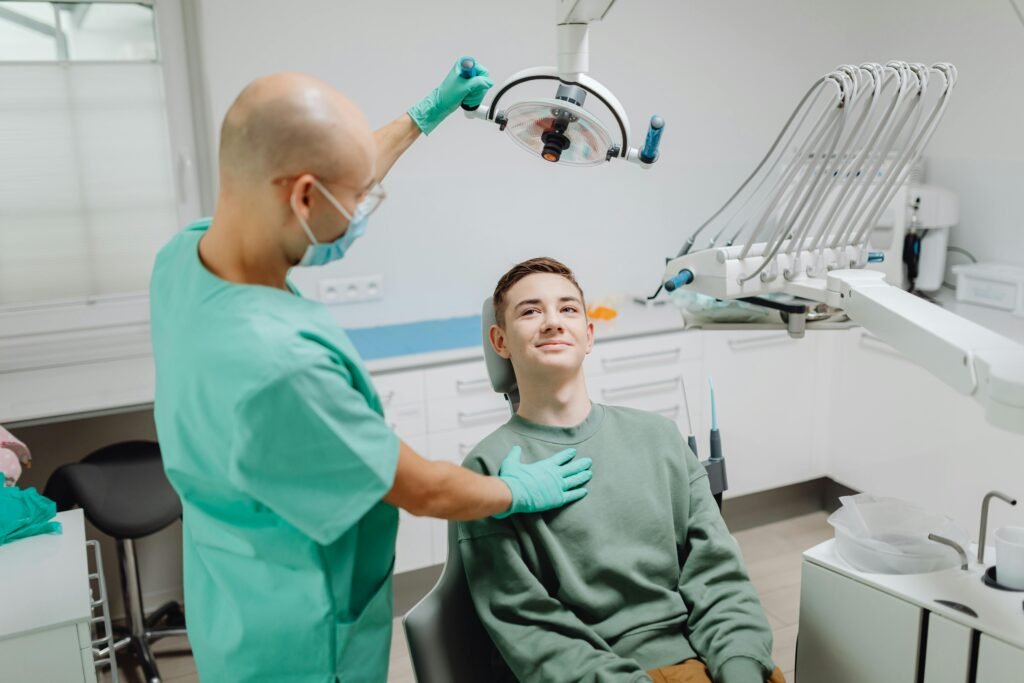 Dentist examining a patient under dental light in a modern clinic setting.